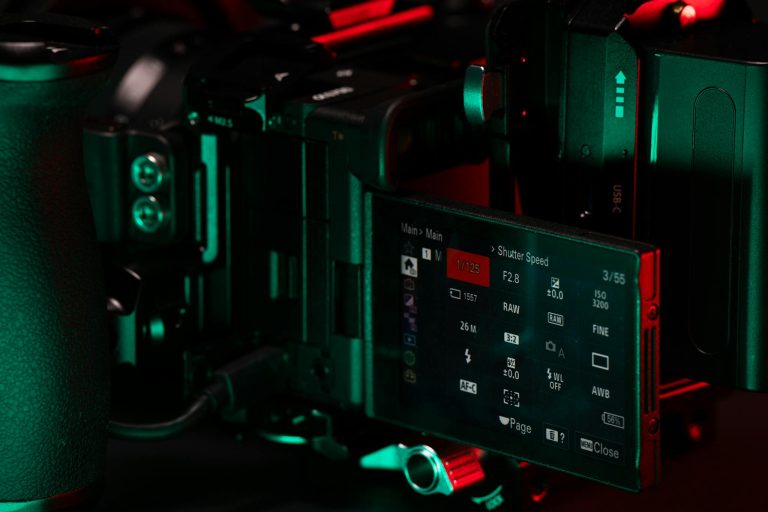 Close-up of a professional video camera setup with an LCD screen displaying settings.