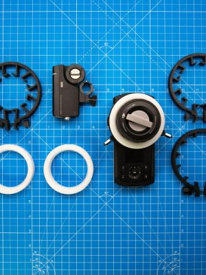 Top view of cinematography gear on a blue grid backdrop for precision setup.
